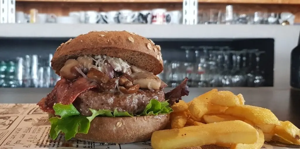 Hamburguesa artesanal con patatas fritas servida en Teckel Bar