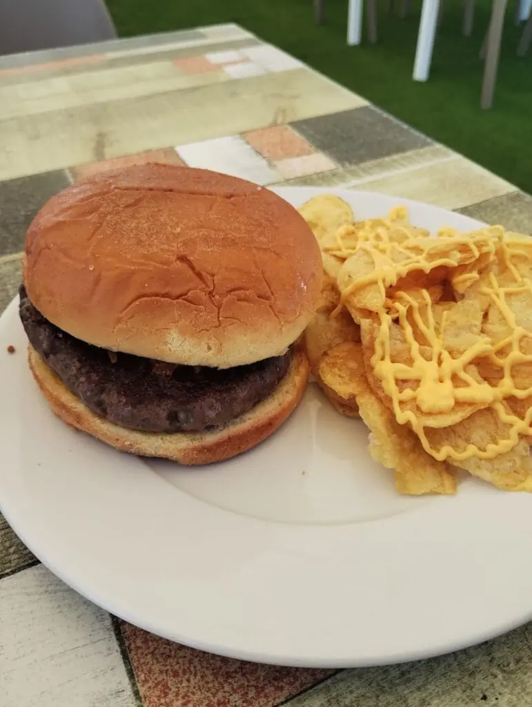 Hamburguesa con patatas servida en Umai Beach