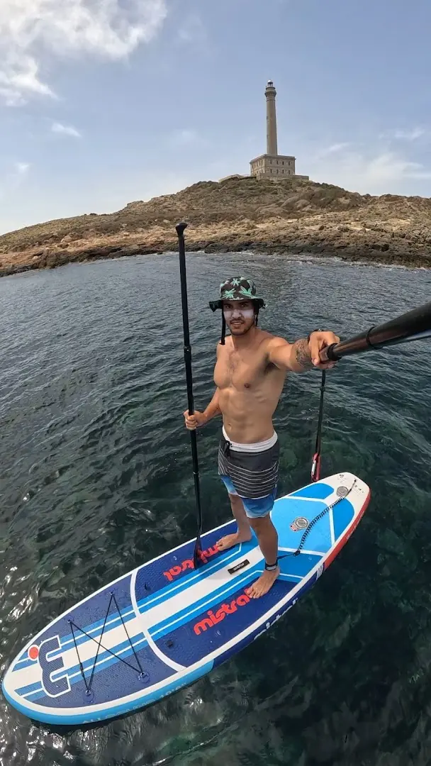 Alumno de Wimbi practicando paddle surf frente al faro de Cabo de Palos