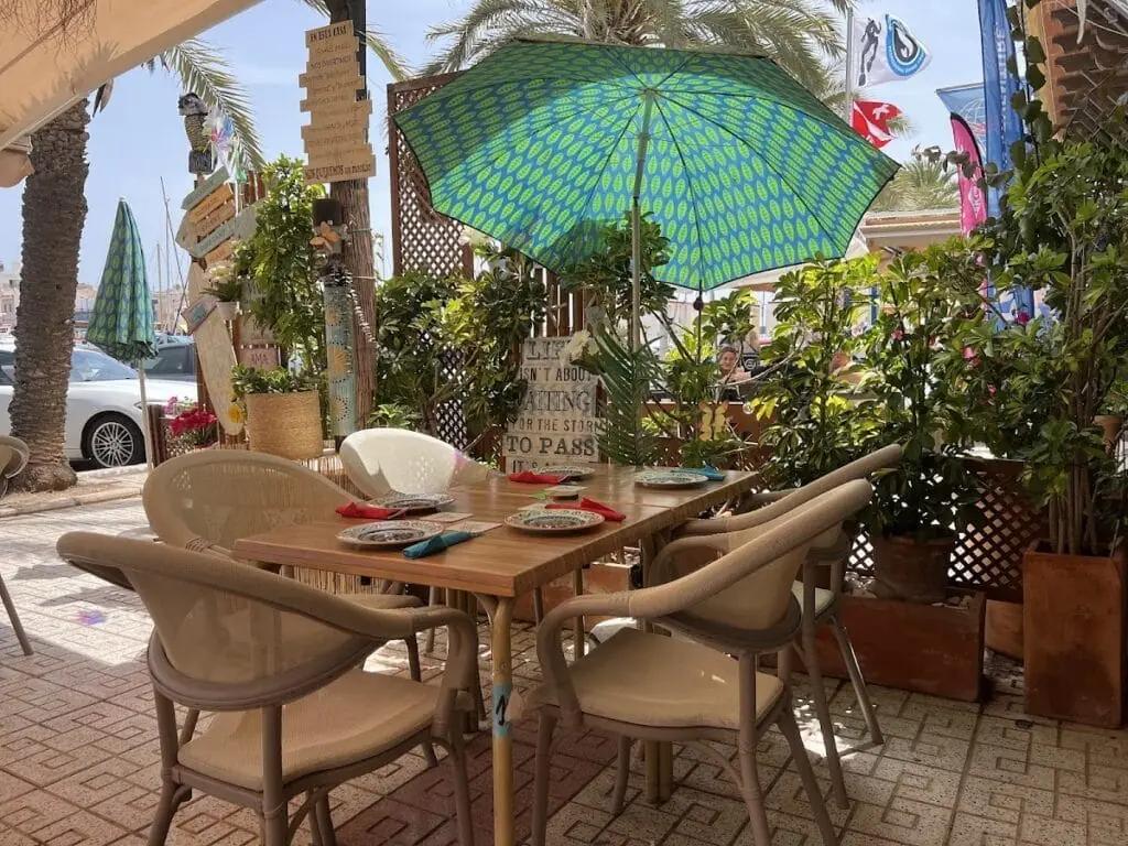 Terraza exterior de Yemanjá con sombrillas en el puerto de Cabo de Palos